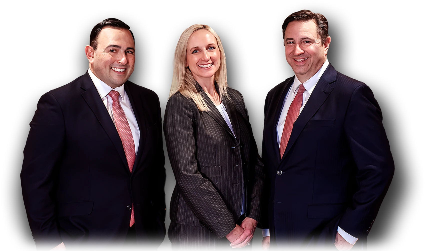 Three smiling professionals, two men in suits and one woman in a pinstripe suit, stand together as a team.
