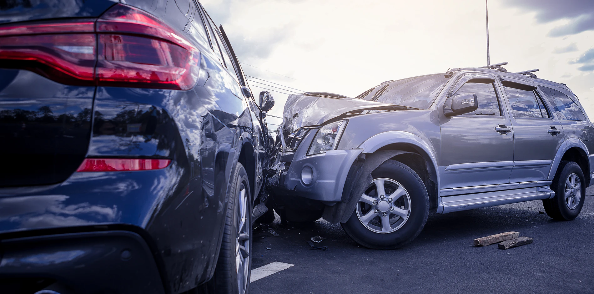 Black SUV's rear and grey SUV's front are heavily damaged from a personal vehicle collision.