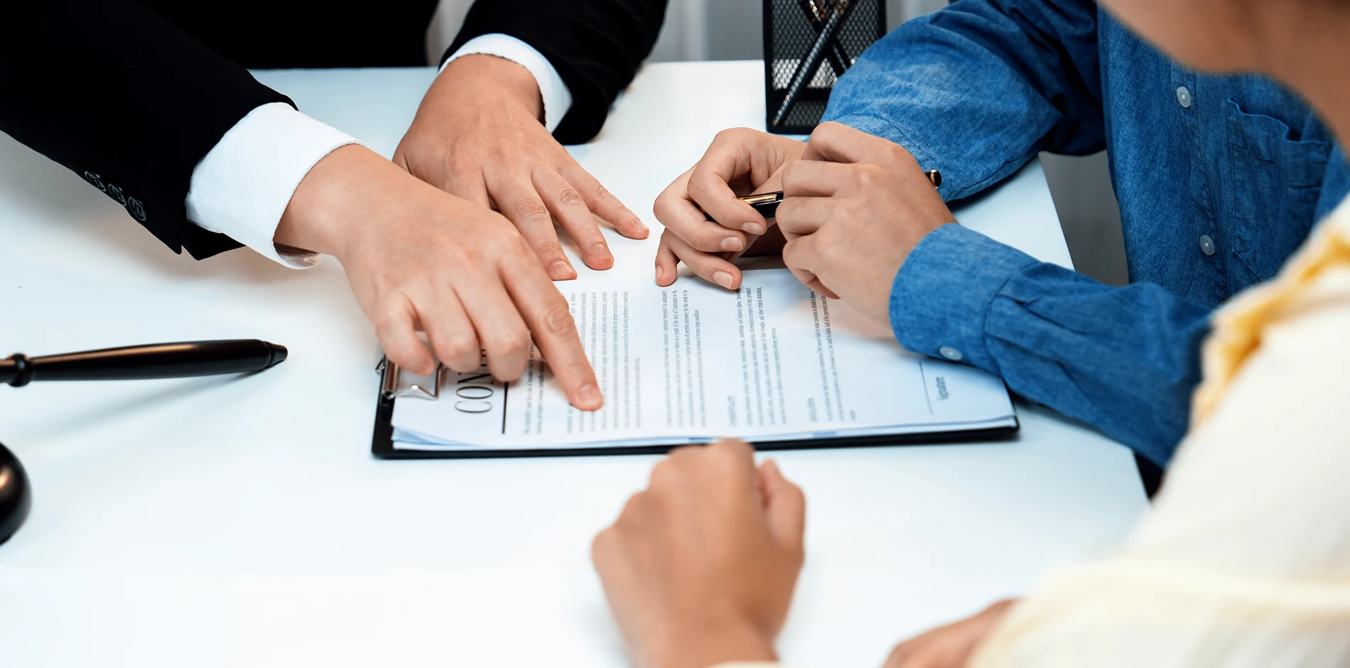 Property Desktop points to a contract as a client prepares to sign, with a gavel on the white desk.